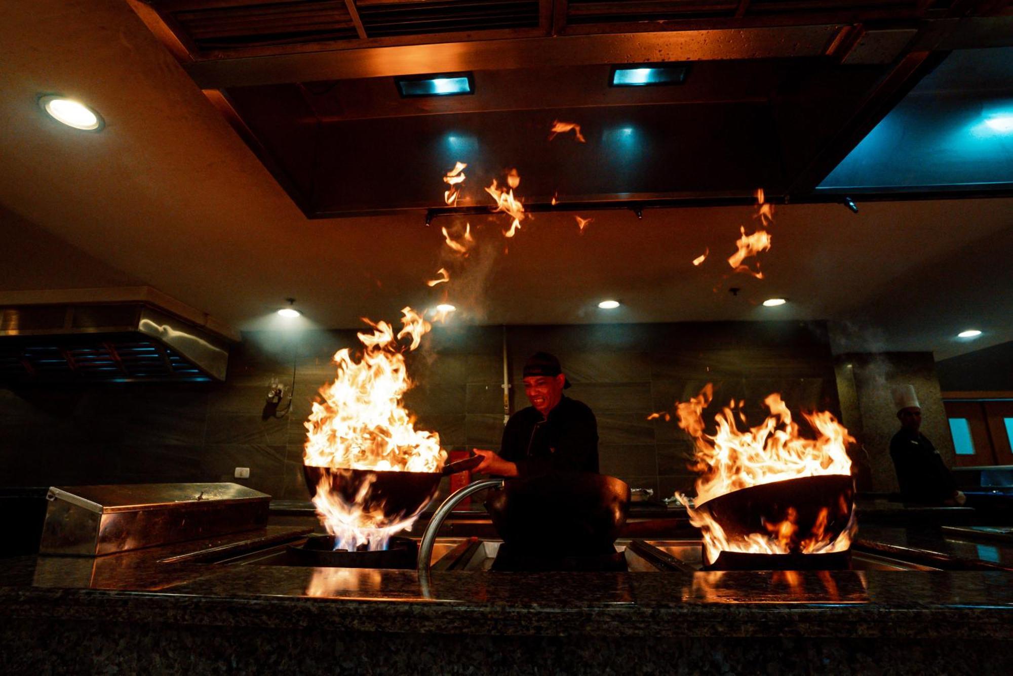 The V Luxury Resort Sahl Hasheesh Hurghada Luaran gambar A chef cooking with a wok